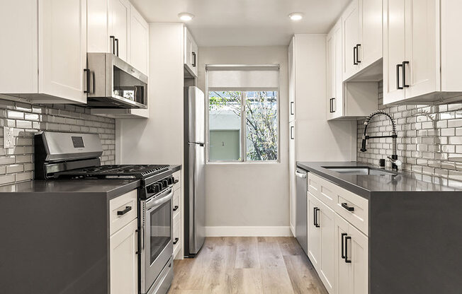 Kitchen with stainless steel fridge, oven, and microwave.