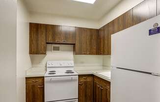 A kitchen with a white stove and refrigerator.