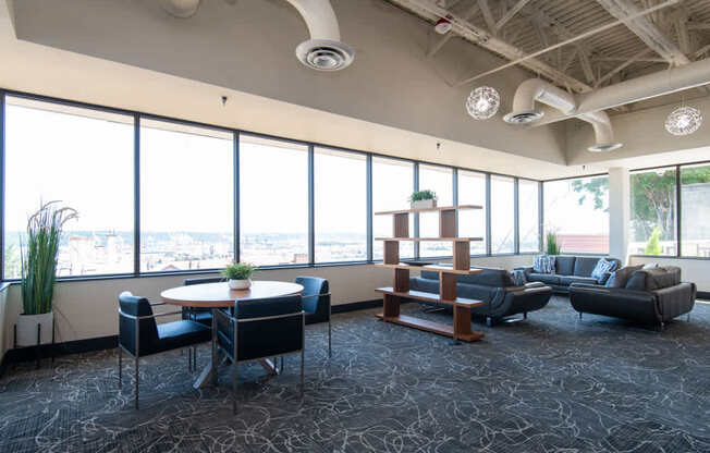 A conference room with a table, chairs, and a view of the city.