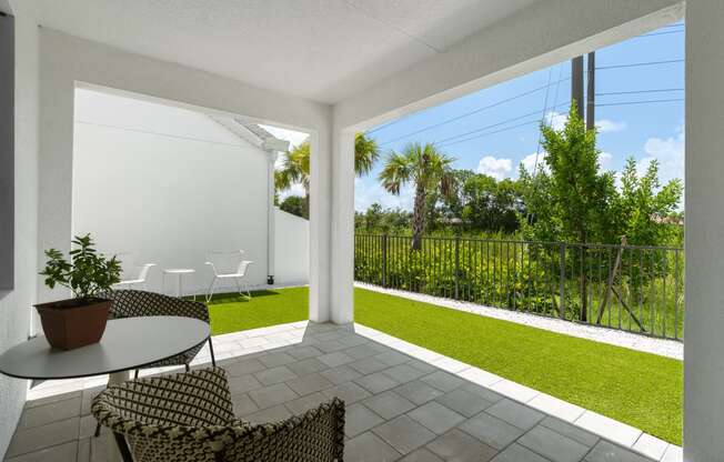 a patio with two chairs and a table and a lawn at Odyssey, Florida, 33905