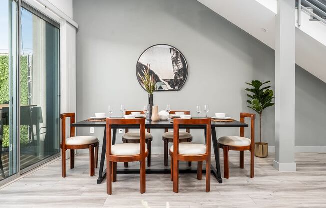 a dining room with a table and chairs and a mirror on the wall