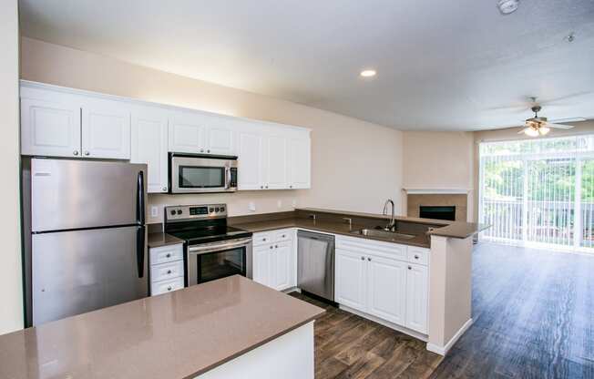 Spacious Model Living Room with Faux Wood Floors and Brick Wood-Burning Fireplace in Orenco Station Apartment