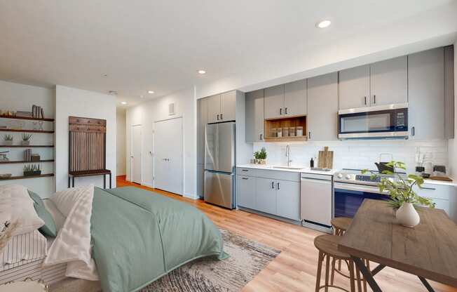a bedroom with a bed and a kitchen with blue cabinets
