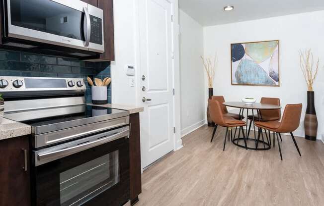 A modern kitchen with a dining table and chairs.