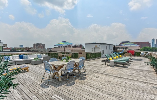Rooftop deck with tables and chairs and a city in the background at The View at Old City, Philadelphia