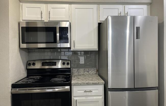 a stove top oven sitting inside of a kitchen with stainless steel appliances