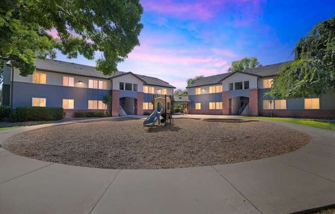 A courtyard with a playground in the middle of a building complex.