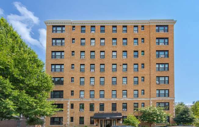 a tall brick building with cars parked in front of it