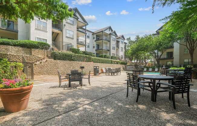 An al fresco dining patio with tables and chairs at Jefferson Place Apartments in Irving, TX
