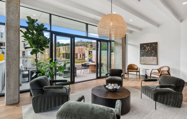 A living room with a large window and a view of a building outside.