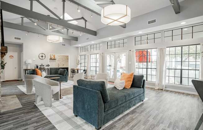 a large living room with couches and chairs and windows