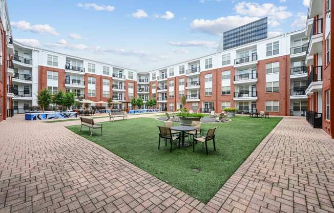 Outdoor courtyard with seating and landscaped gardens at The Grand at Upper Kirby apartments in Houston, TX