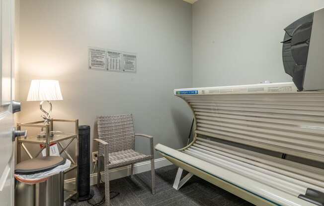 a patient room with a bench and a table with a lamp and a chair