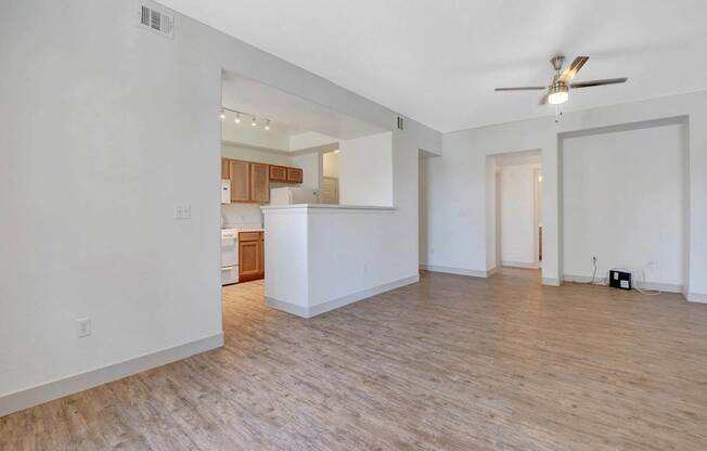 A room with a ceiling fan and wooden flooring.
