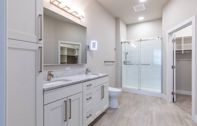 a bathroom with a toilet sink and a shower with a glass door