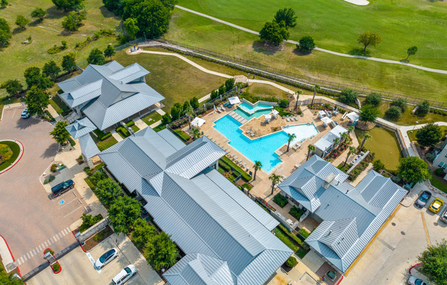 arial view of a resort style pool surrounded by gray roofs