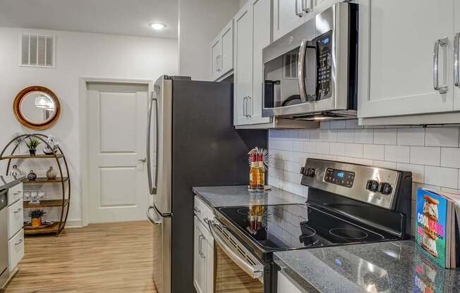 A modern kitchen with a black refrigerator and stove top oven.