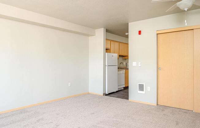 A room with a carpeted floor and a ceiling fan.