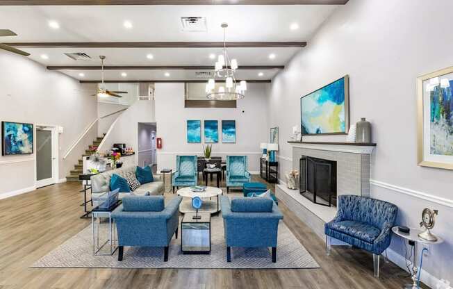 a living room with blue chairs and a fireplace  at The Park at Chesterfield Apartment Homes, Tampa, FL, 33617