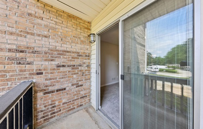 A balcony with a glass door at Gwinnett Square Apartments in Duluth, GA