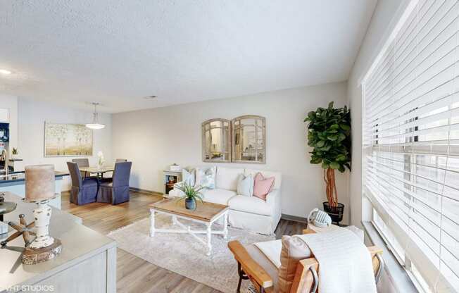 a living room with white furniture and a large window