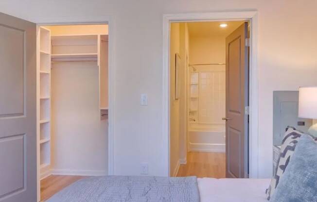 a bedroom with a bed and a closet with a door open