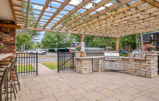 a patio with a pergola and an outdoor kitchen