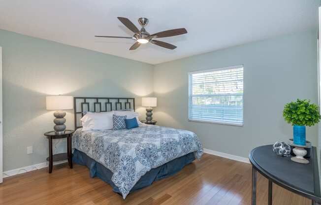 the master bedroom has a large bed and a ceiling fan