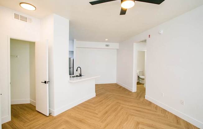 A room with a ceiling fan and a counter with a sink.
