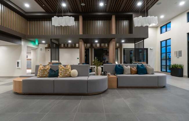A modern living room with a grey sofa and a wooden ceiling.