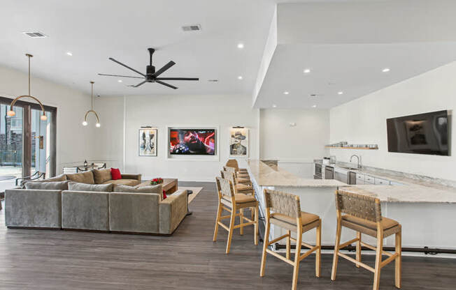 A modern living room with a grey couch and wooden chairs.