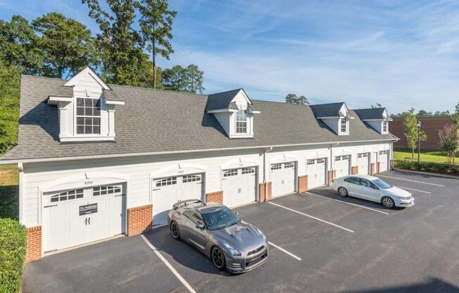 a parking lot with two cars in front of a garage at Sterling Manor, Williamsburg Virginia