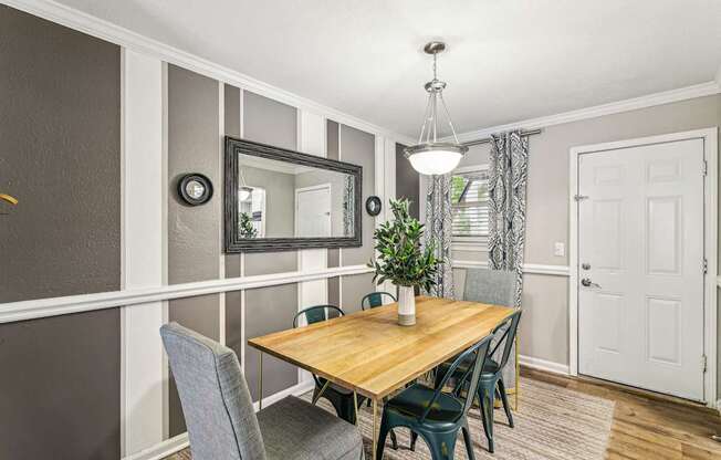 A dining room with a wooden table and grey chairs.