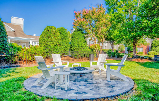 A backyard with a fire pit and chairs.