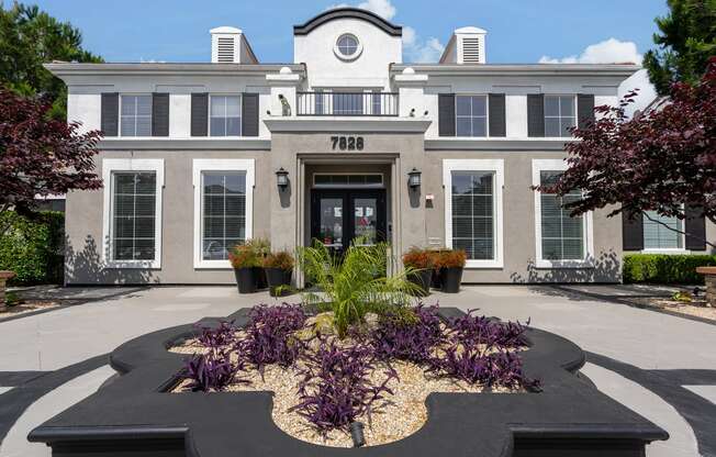 the front of a building with a garden in front of it