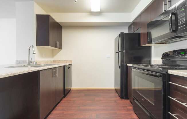 a kitchen with dark wood cabinets and stainless steel appliances