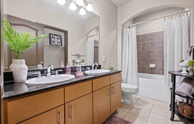 a bathroom with two sinks and a toilet and a shower