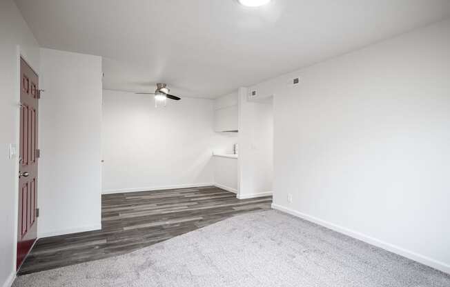 an empty living room with white walls and wood flooring