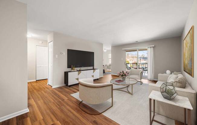 A living room with a white couch, a coffee table, and a television.