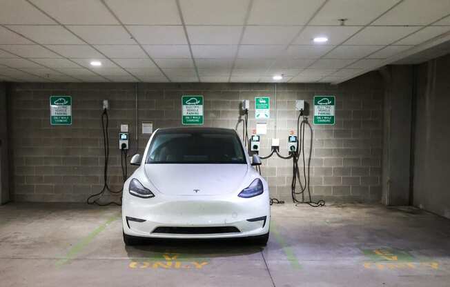a white tesla car parked at a charging station