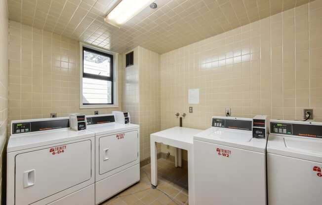 a laundry room with four washes and three washing machines
