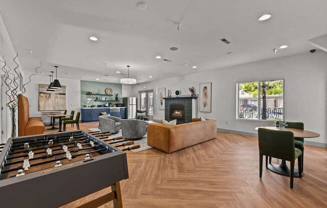 A living room with a foosball table in the foreground.