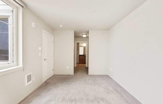 A room with white walls and carpeted floor.