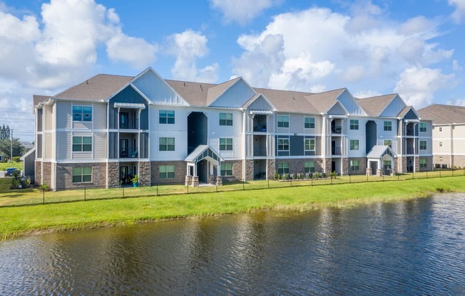 A large apartment complex with a pond in front at Mode at Melbourne, LLC Apartments, Melbourne, FL, 32901