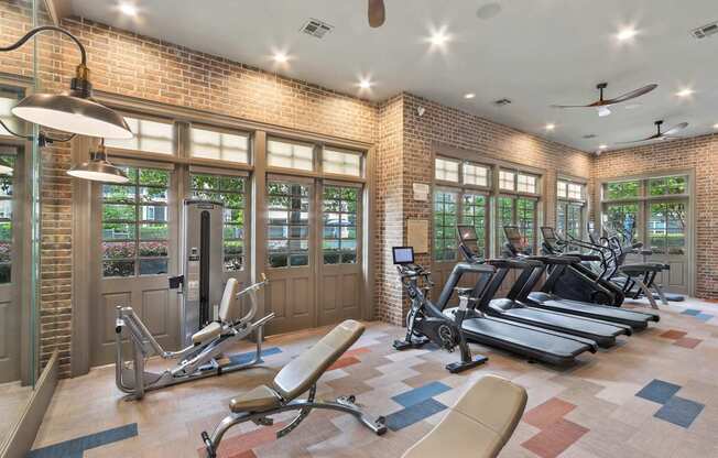 A gym with a brick wall and a variety of exercise equipment.