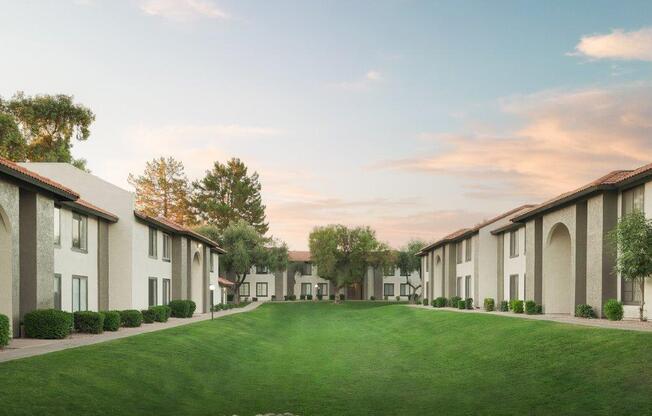 a green lawn in front of a row of houses