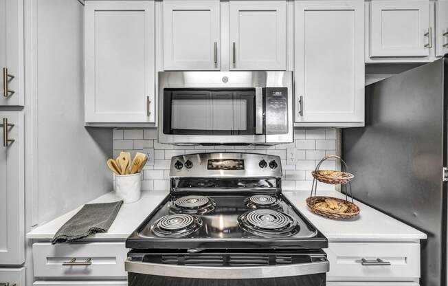 a kitchen with white cabinets and a stove and a microwave