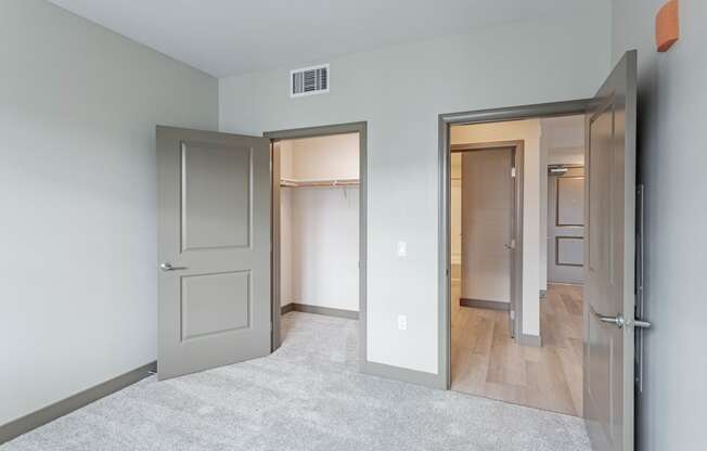 Bedroom with walk in closet and door to living room at Bayswater Apartments, California
