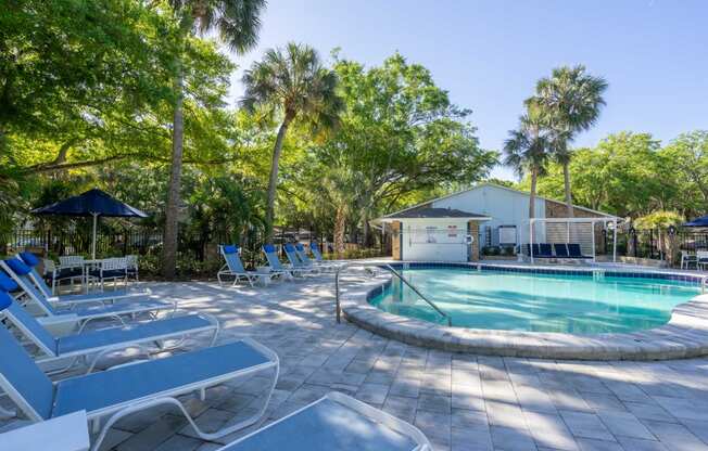 a pool with lounge chairs and a building in the background