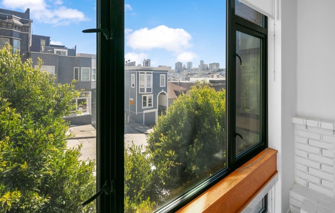 a large window with a wooden ledge and a view of the city